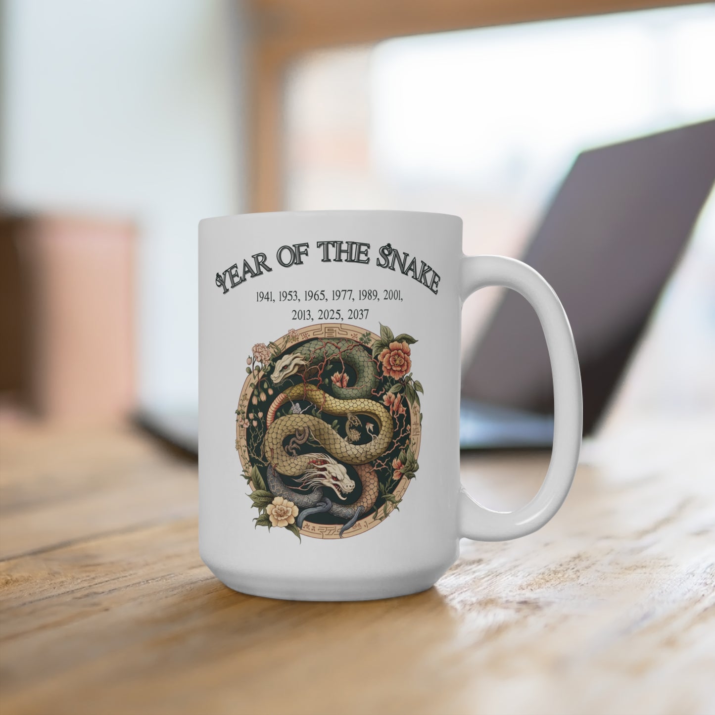 White mug with 'Year of the Snake' design on a wooden surface