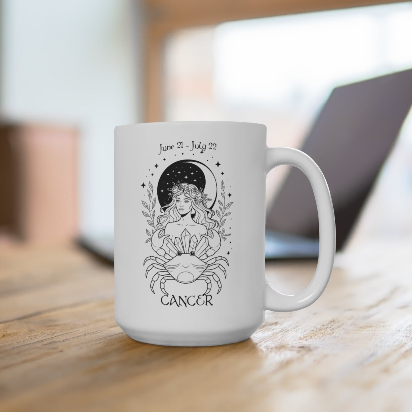 White mug with Cancer zodiac design on a wooden surface