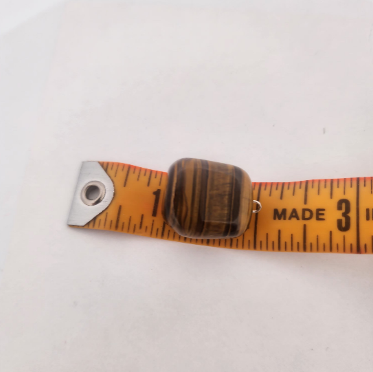 Wooden measuring tape with metal clip on a white background