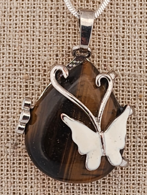 Pendant with butterfly design on a brown stone background
