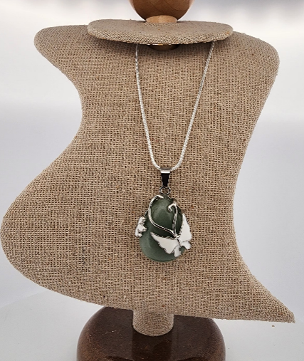 Necklace with a green pendant on a mannequin bust