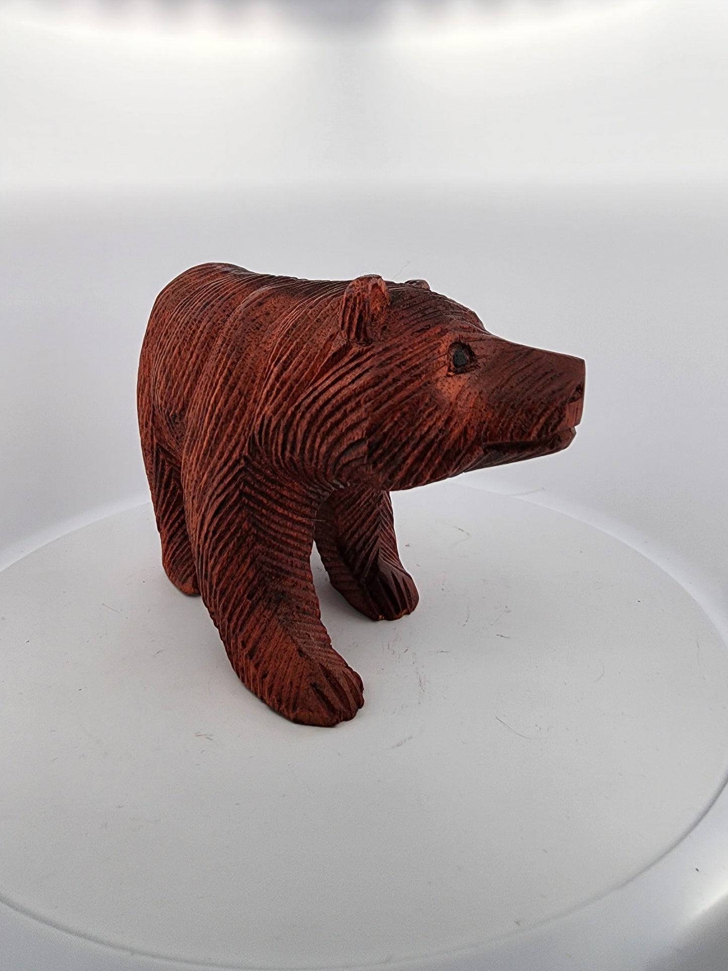 Brown bear figurine on a white platform