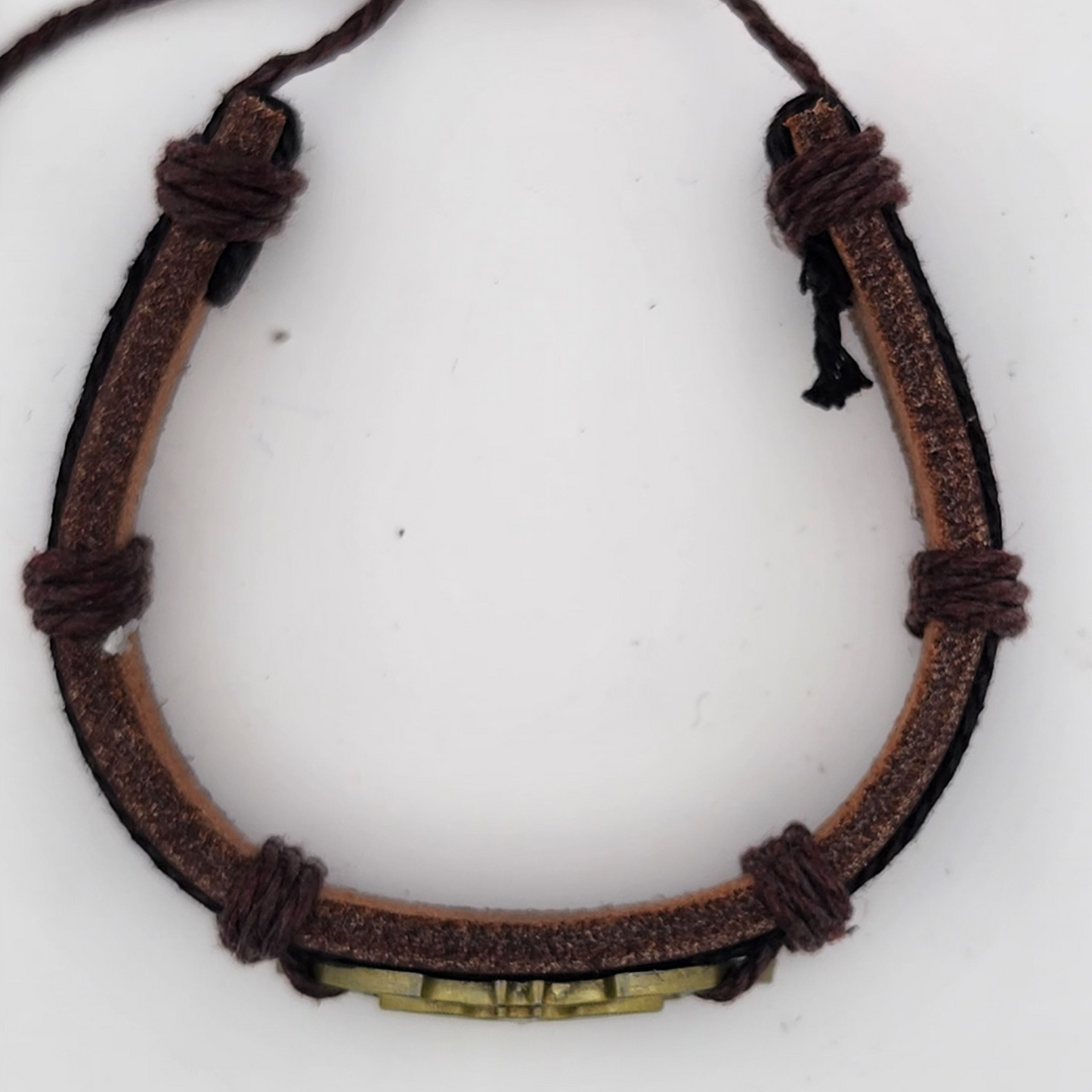 Brown leather bracelet with a metal tag on a white background