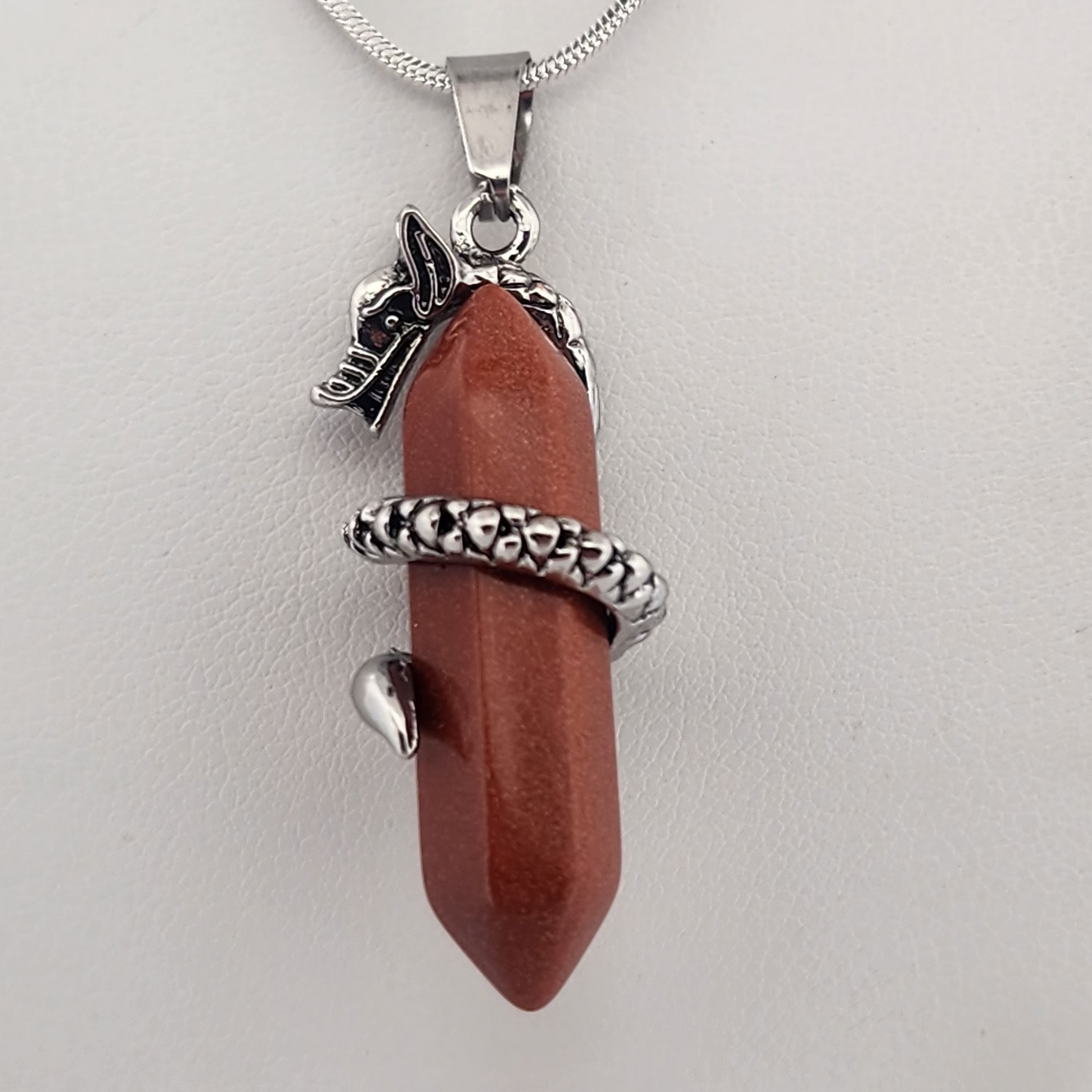 Brown pendant with silver accents on a white background