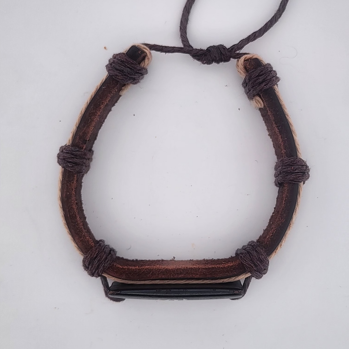 Brown leather bracelet with a black metal clasp on a white background