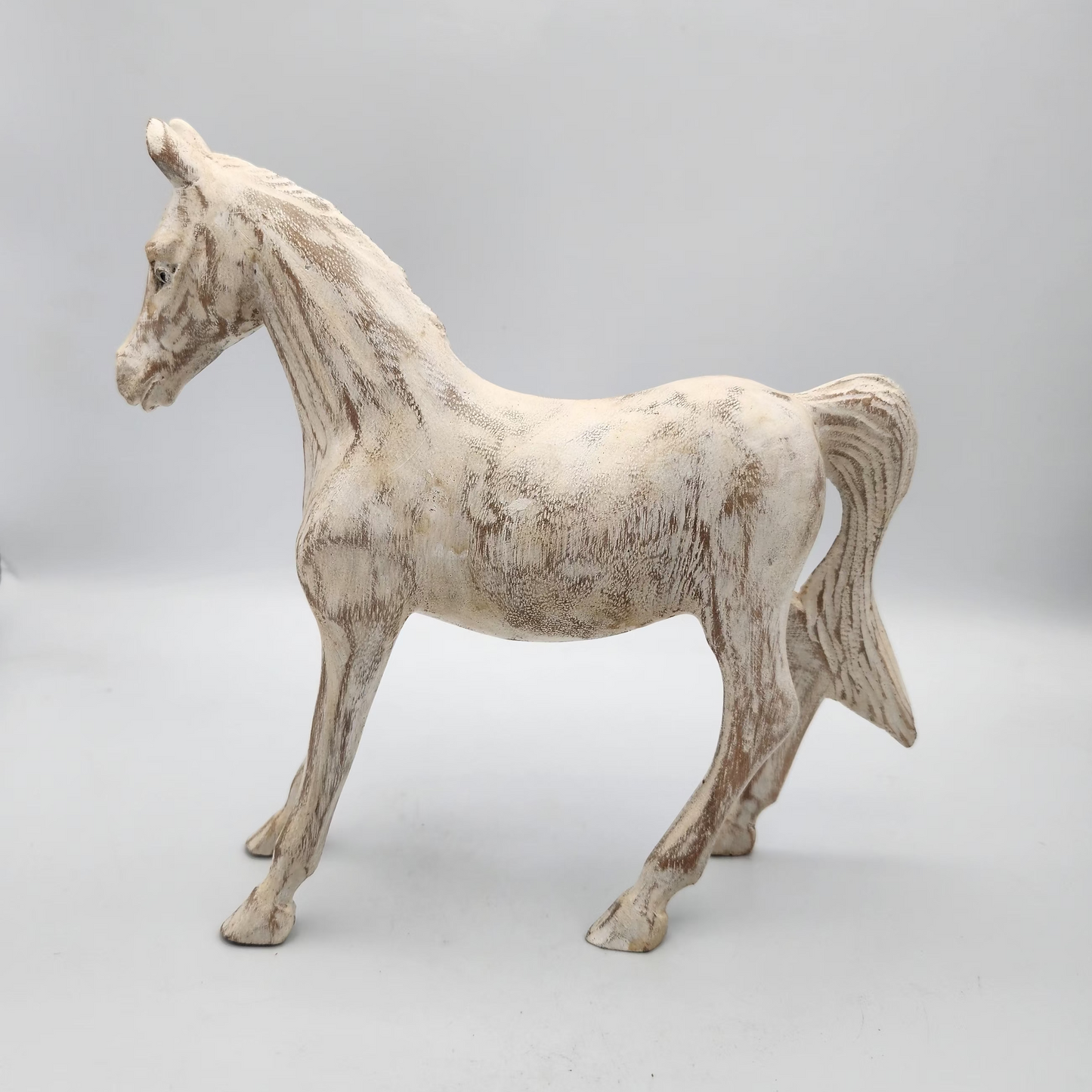 White horse figurine on a light gray background