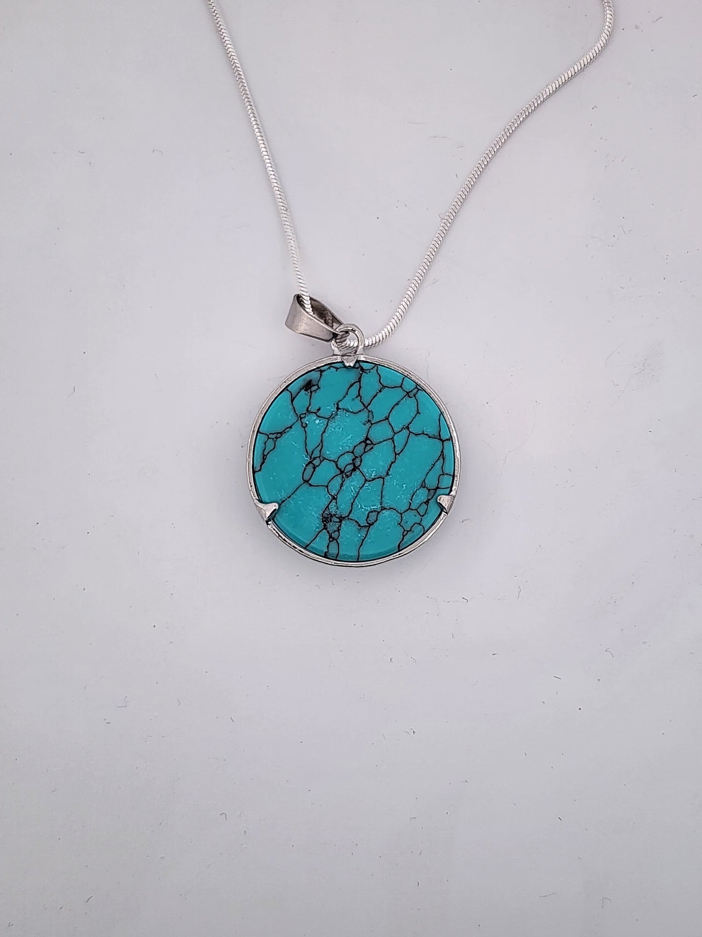 Turquoise pendant necklace on a white background