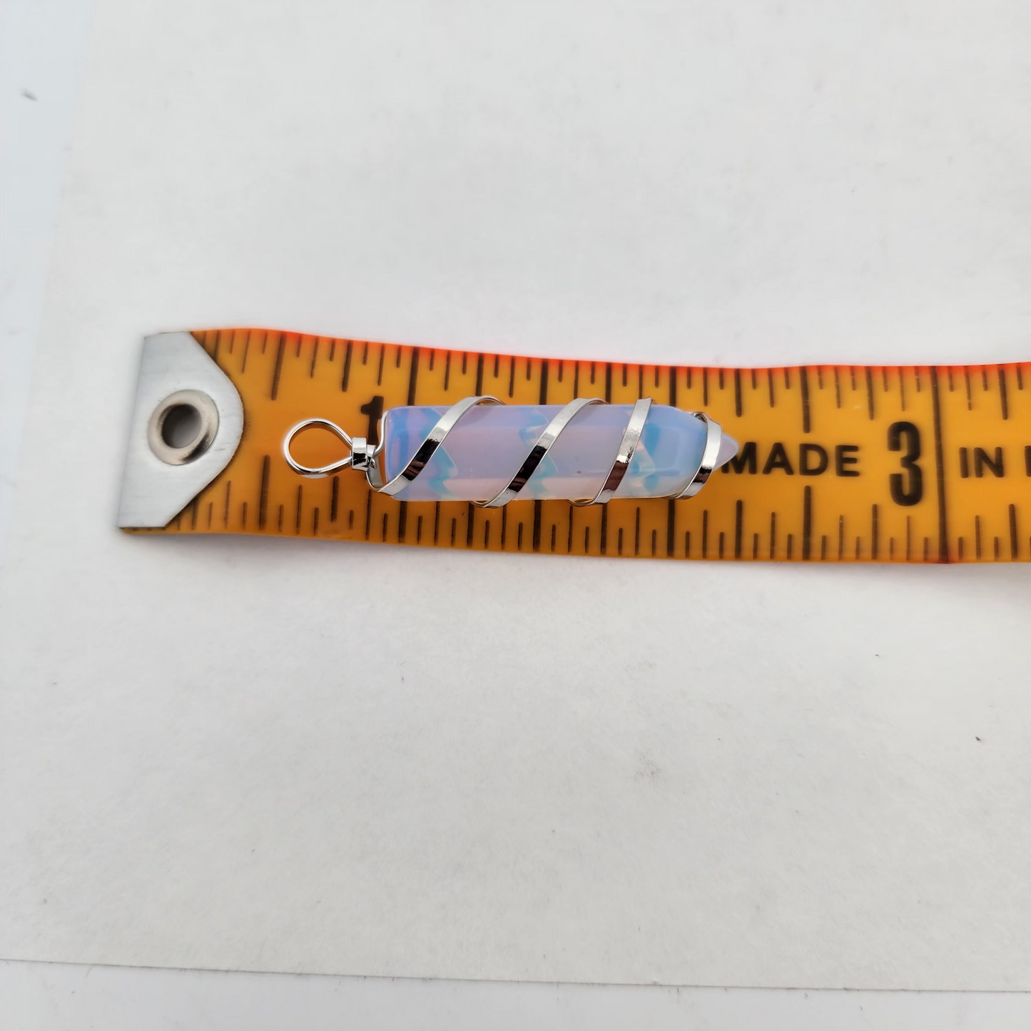 Colorful striped keychain on a measuring tape against a white background