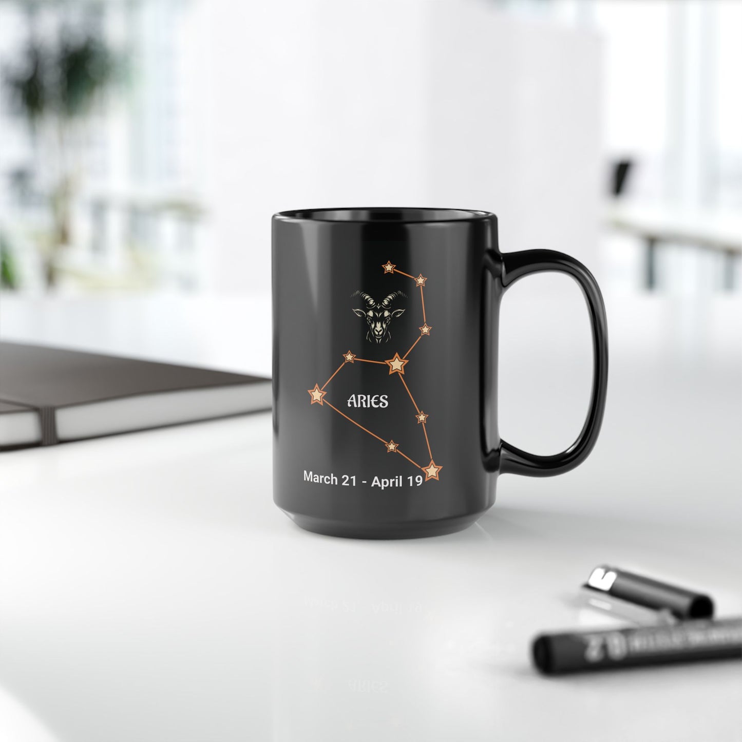 Black mug with Aries constellation design on a white surface