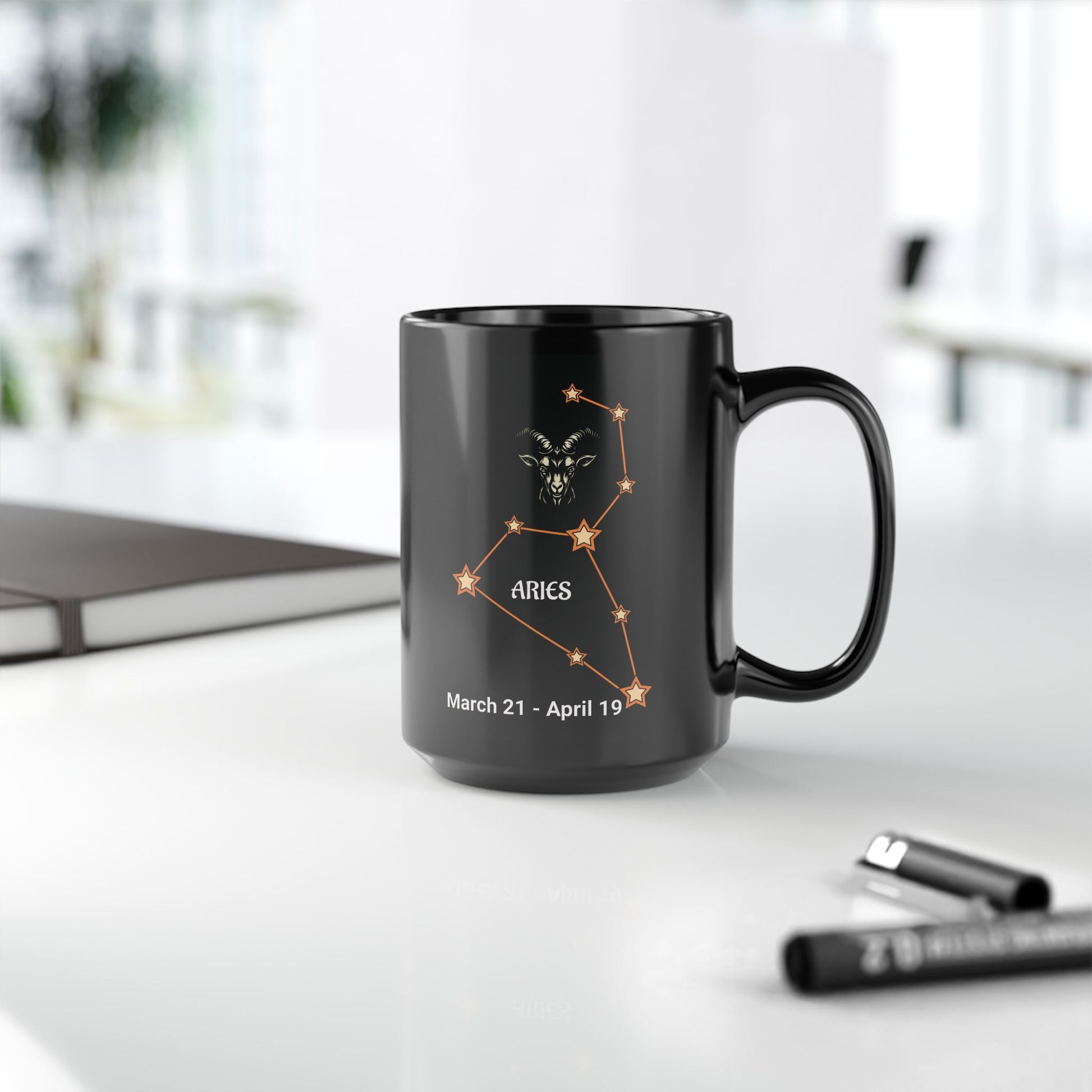 Black mug with Aries constellation design on a white surface