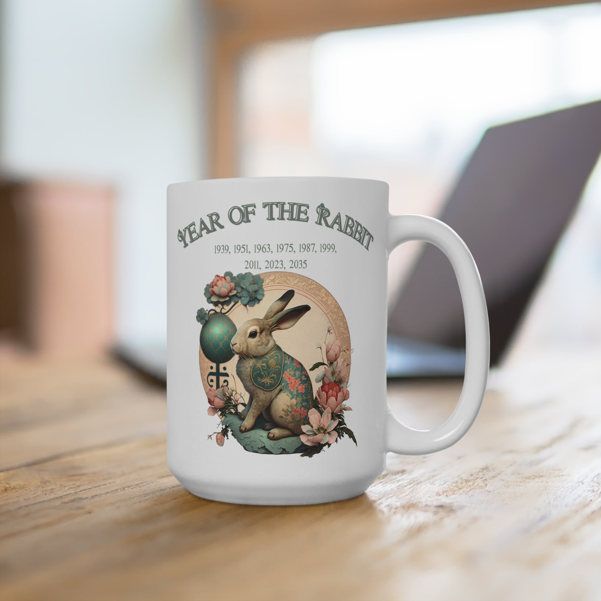 White mug with 'Year of the Rabbit' design featuring a rabbit and floral elements on a wooden surface.