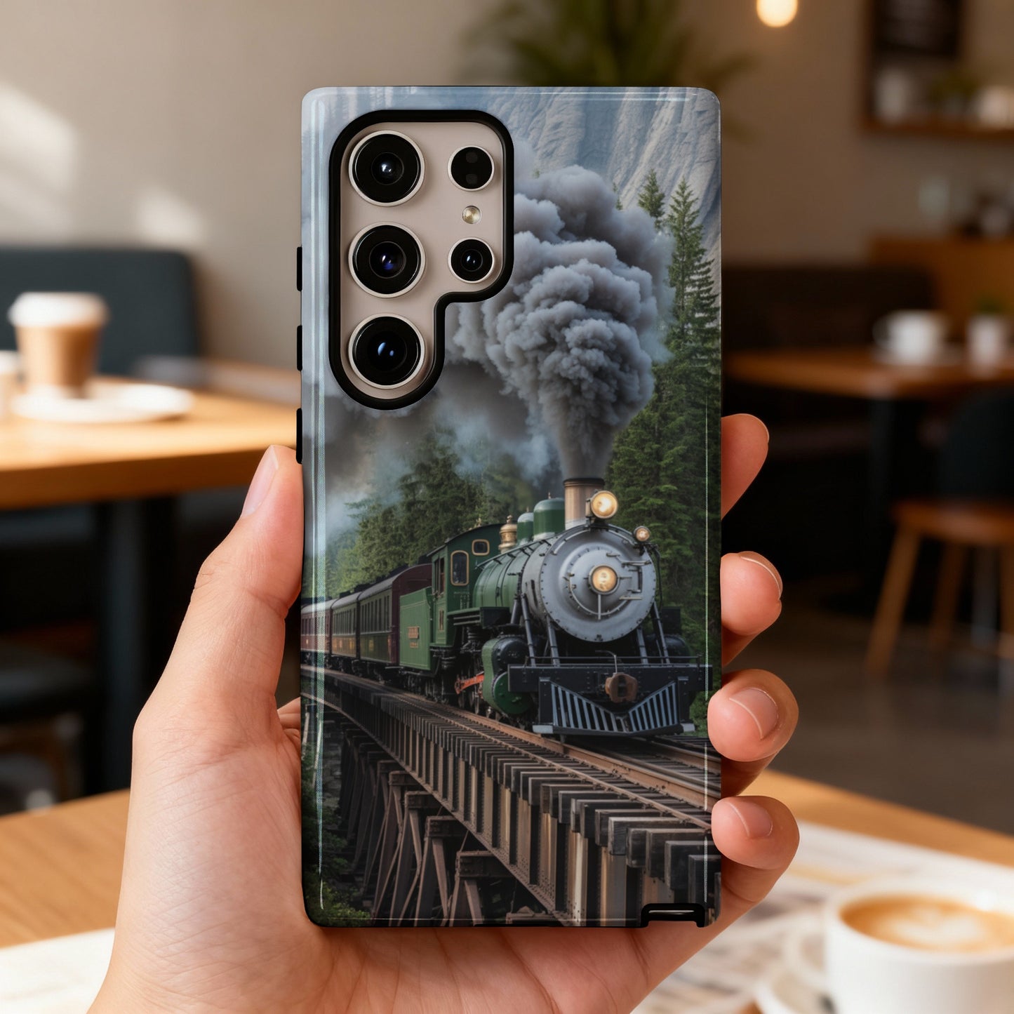 Green steam locomotive crosses wooden bridge in a forest.