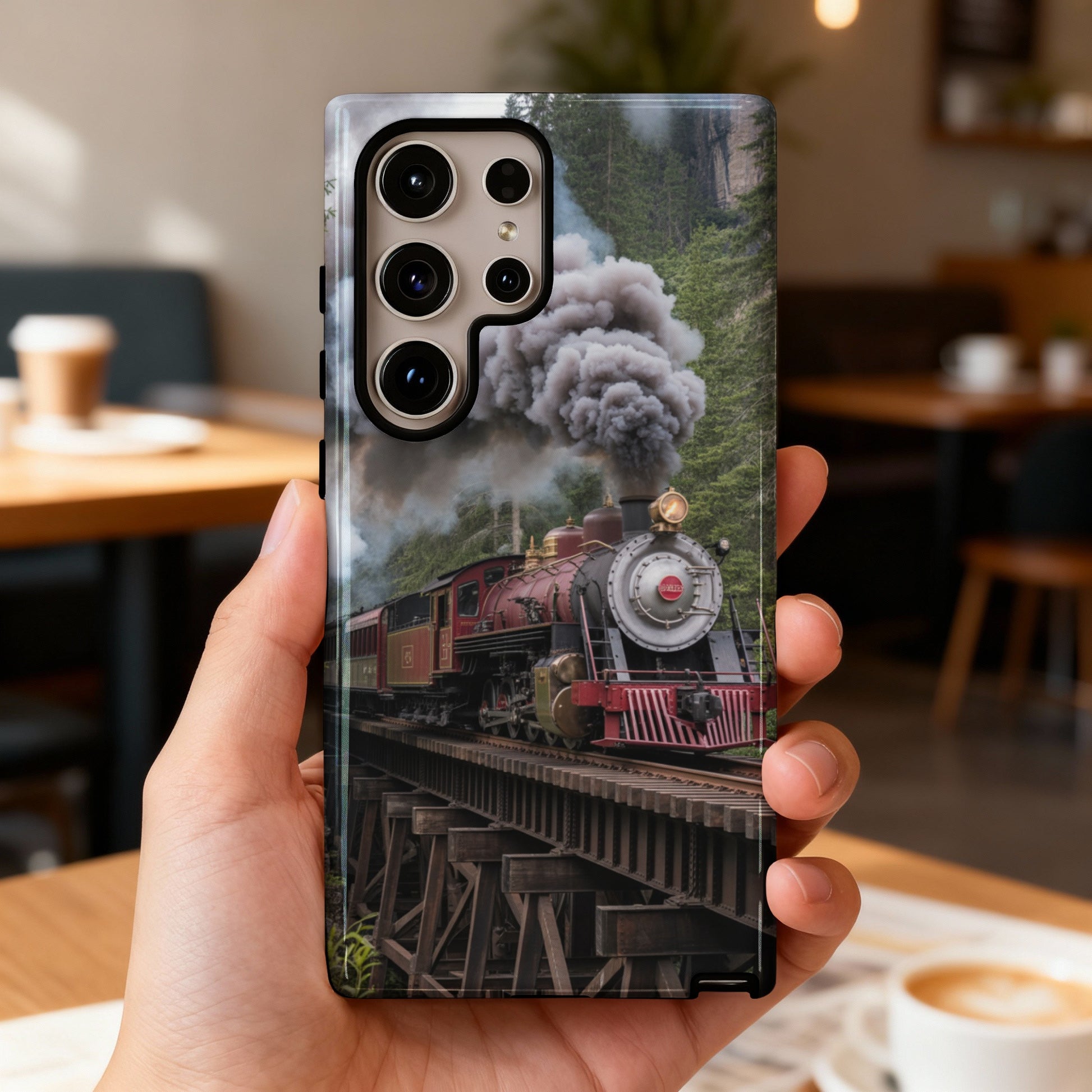 Red steam train crosses a wooden bridge, enveloped in smoke.