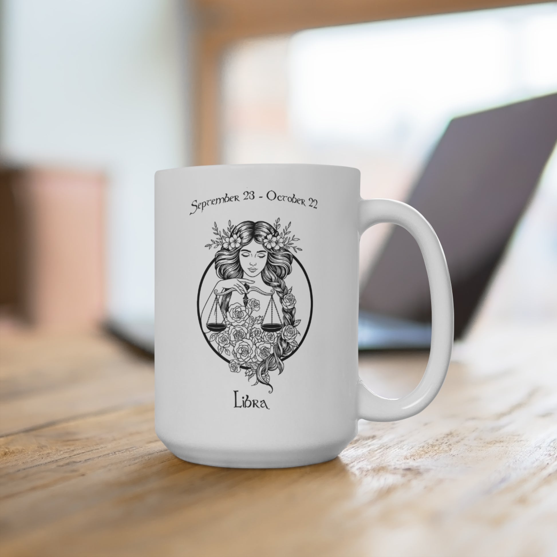 White mug with Libra zodiac design on a wooden surface