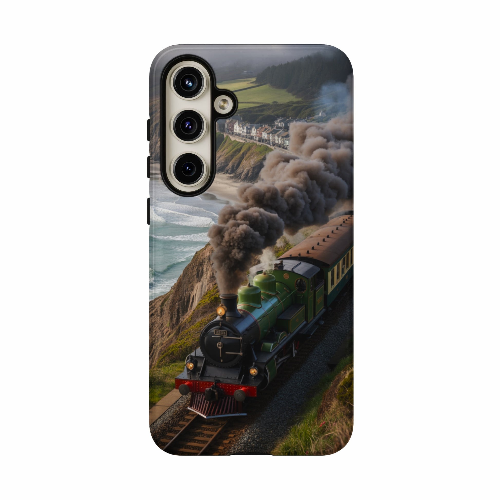 Green steam locomotive travels along a coastal track with houses and ocean in background.
