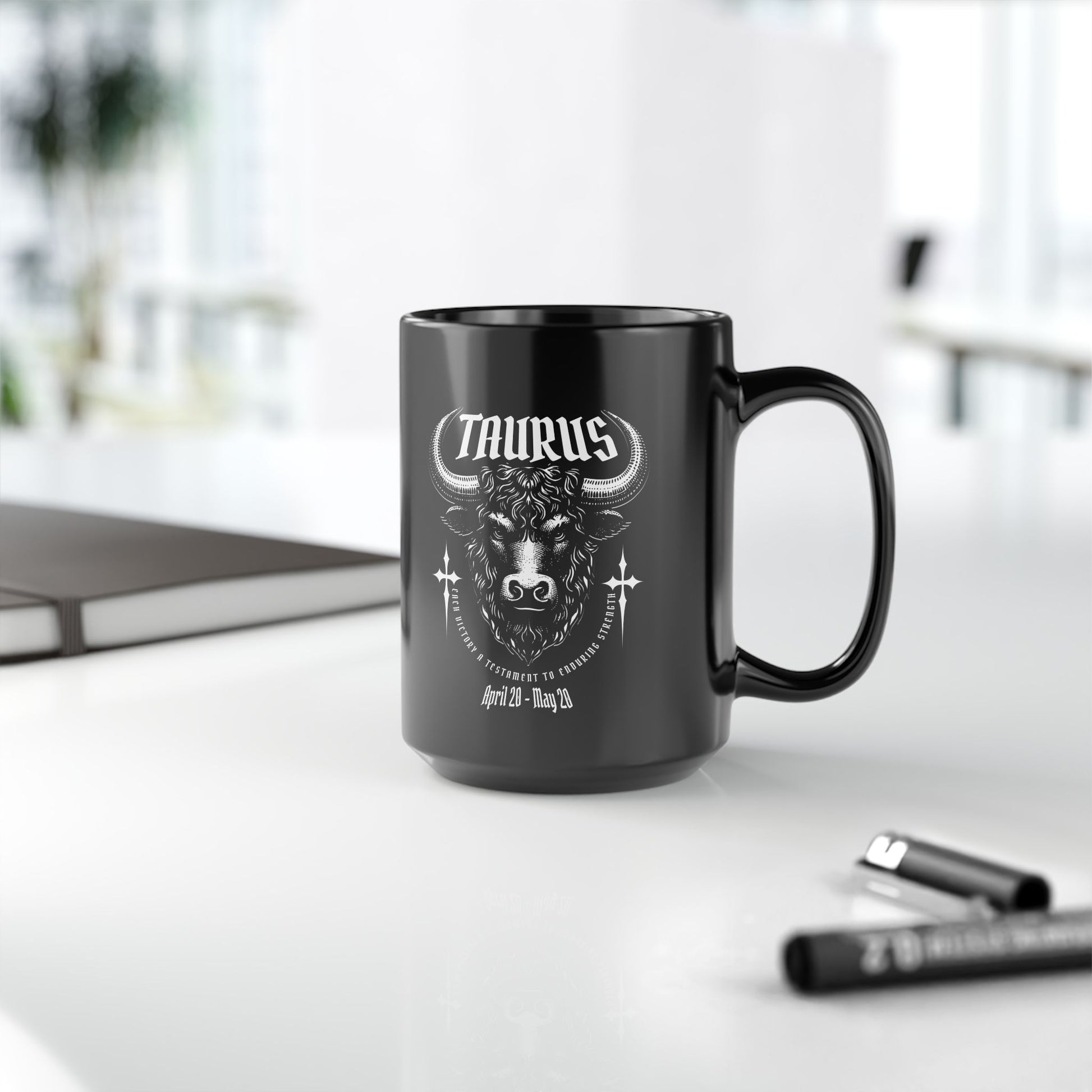 Black mug with Taurus zodiac design on a white surface