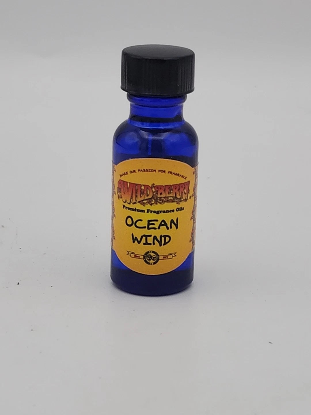 Blue bottle of 'Ocean Wind' fragrance oil with a yellow label on a gray background