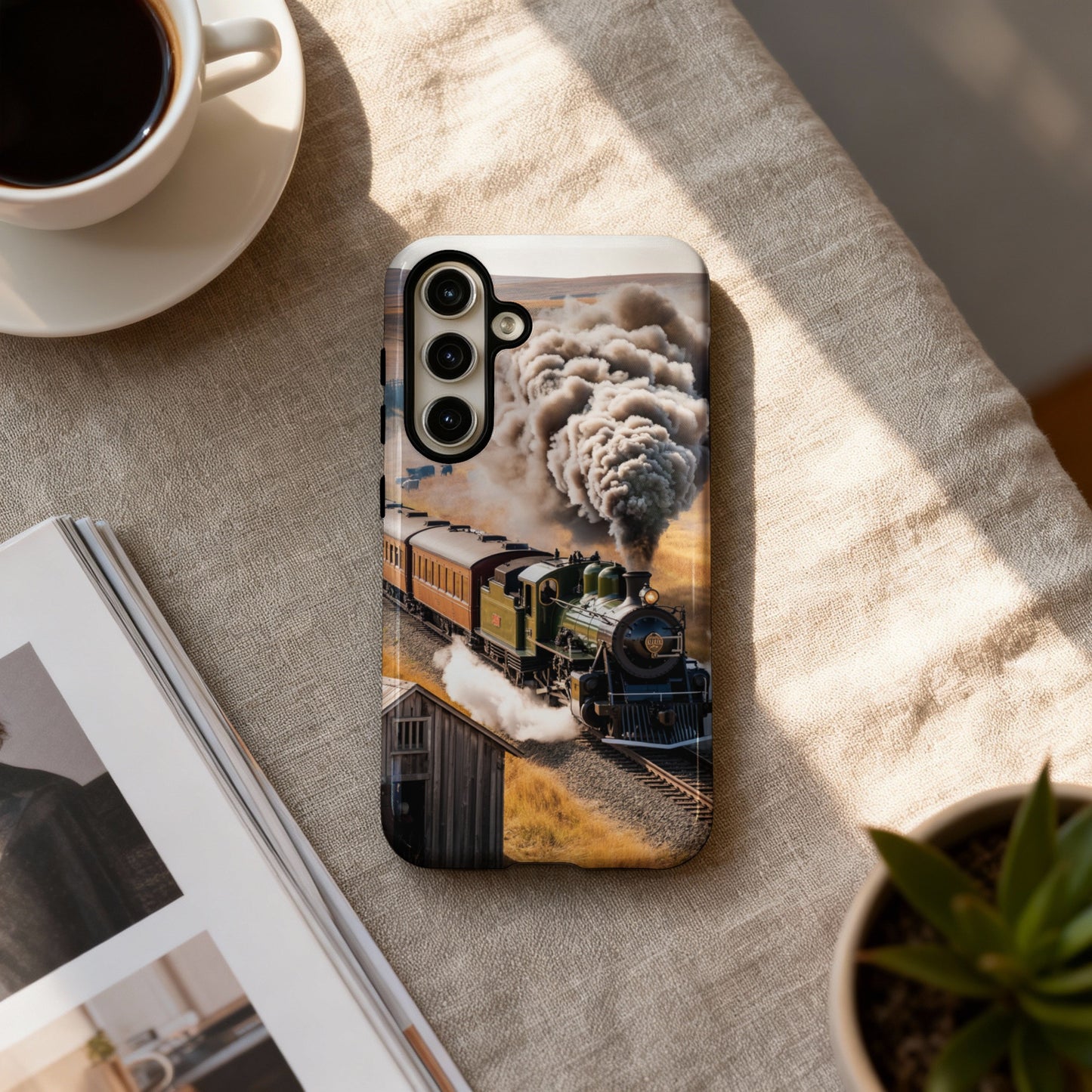 Train emitting smoke on a track, viewed on a phone case.