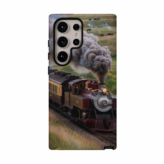 Steam train with cows in a grassy field.