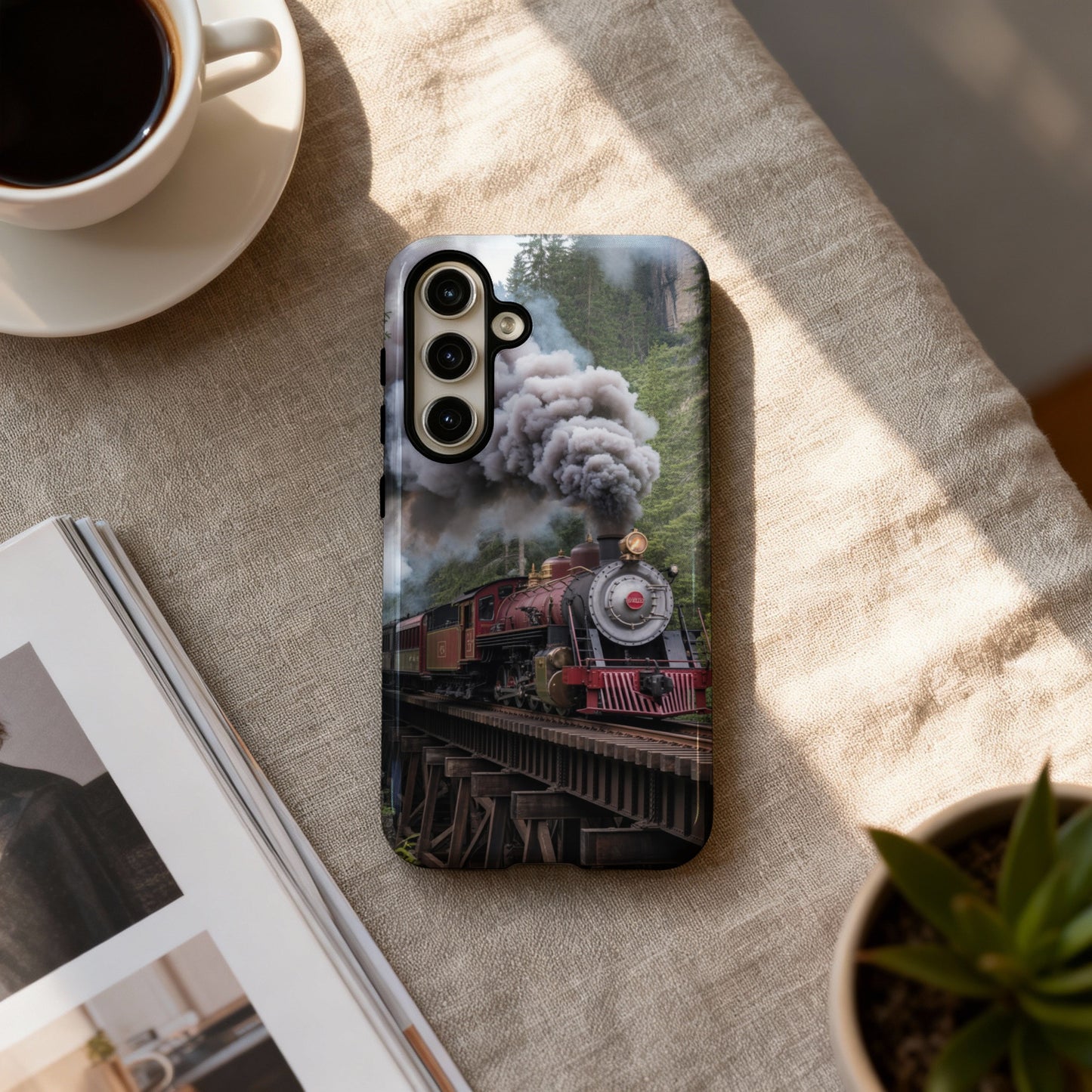 Steam train on a wooden bridge with lush green trees.