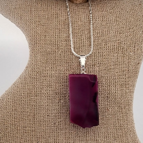 Purple agate pendant on a silver chain displayed on a mannequin bust.