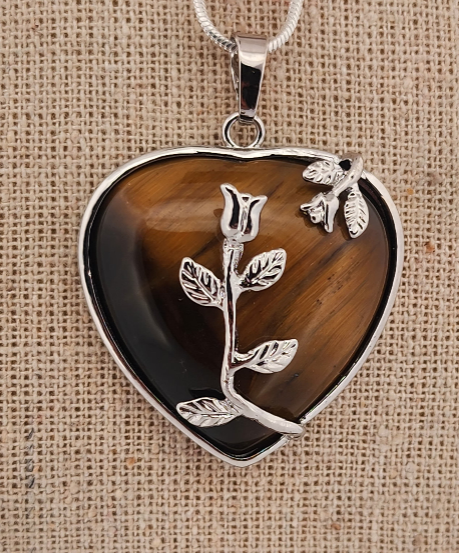 Heart-shaped pendant with floral design on a brown background