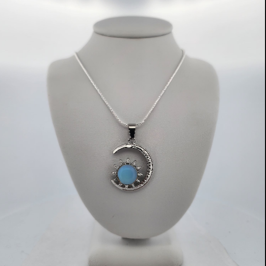 Necklace with a blue pendant on a gray bust against a white background