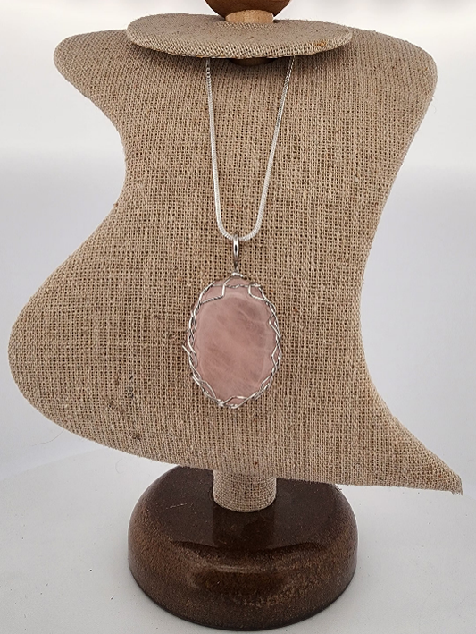 Necklace with a pink pendant on a brown mannequin bust against a white background