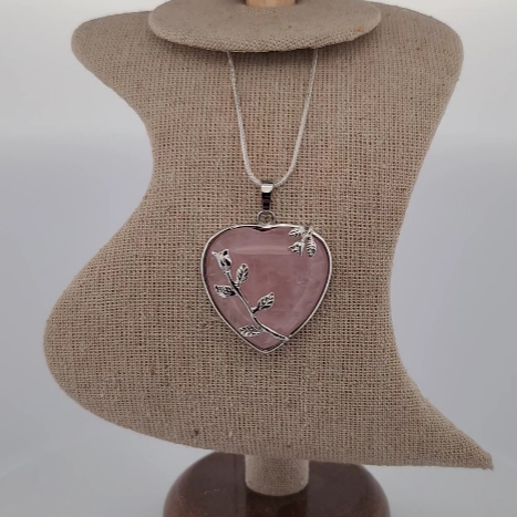 Necklace with a heart-shaped pink pendant on a mannequin bust.