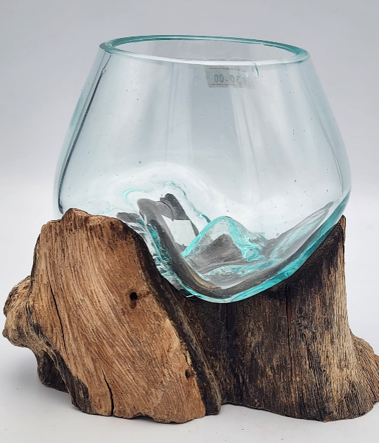 Clear glass bowl on a wooden base against a gray background