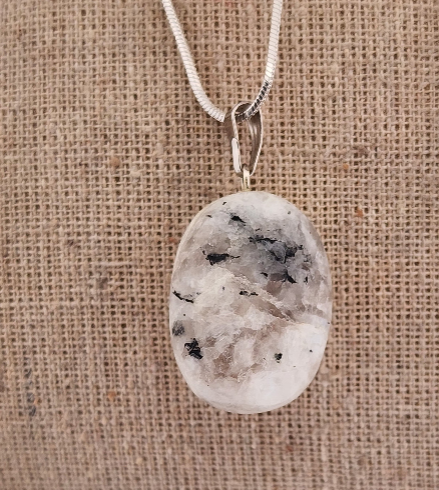 Necklace with a pendant resembling a pebble on a textured beige background