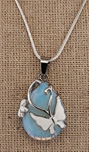 Blue and silver pendant on a chain against a brown fabric background