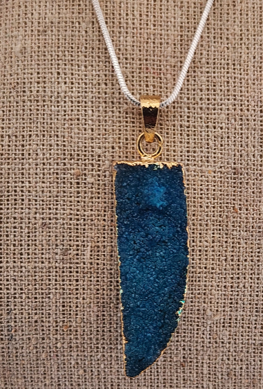 Blue pendant necklace on a textured brown background