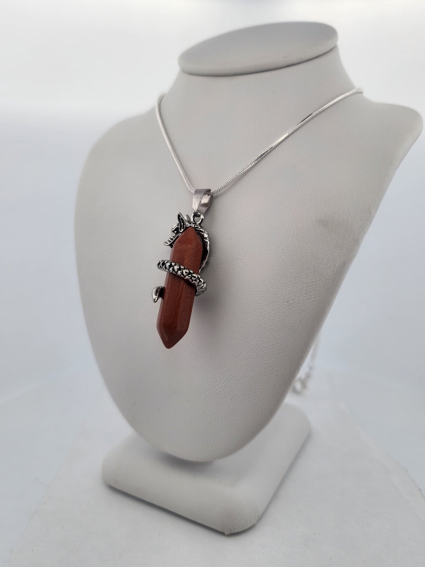 Necklace with a red stone pendant on a gray mannequin bust against a white background