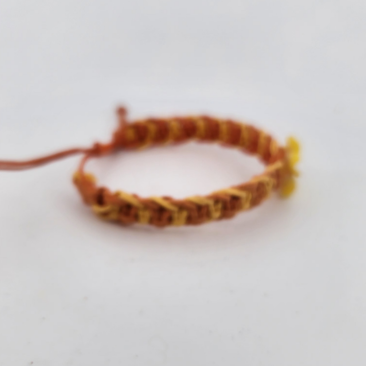Bracelet with red and yellow pattern on a light gray background