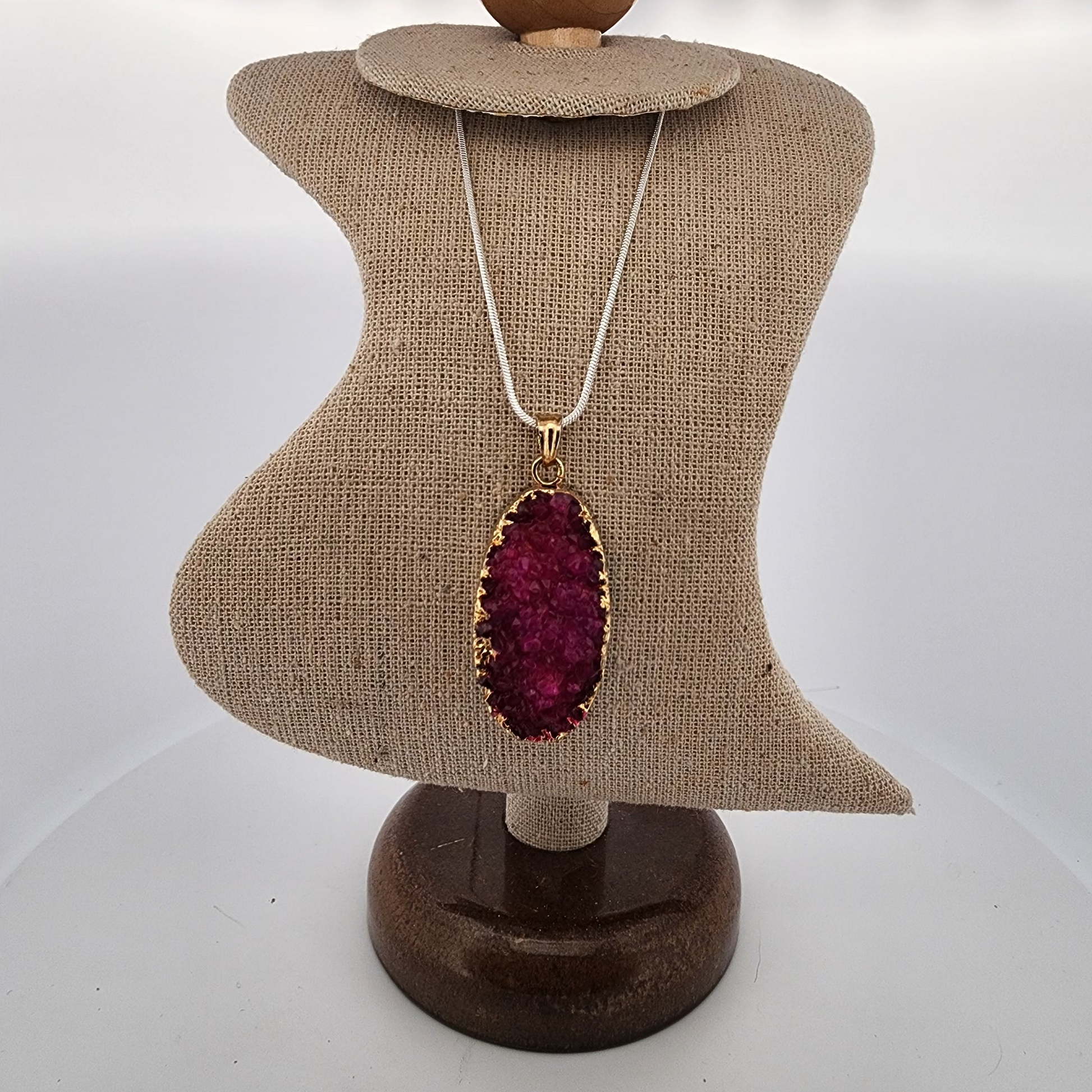 Necklace with a red pendant on a mannequin bust against a white background