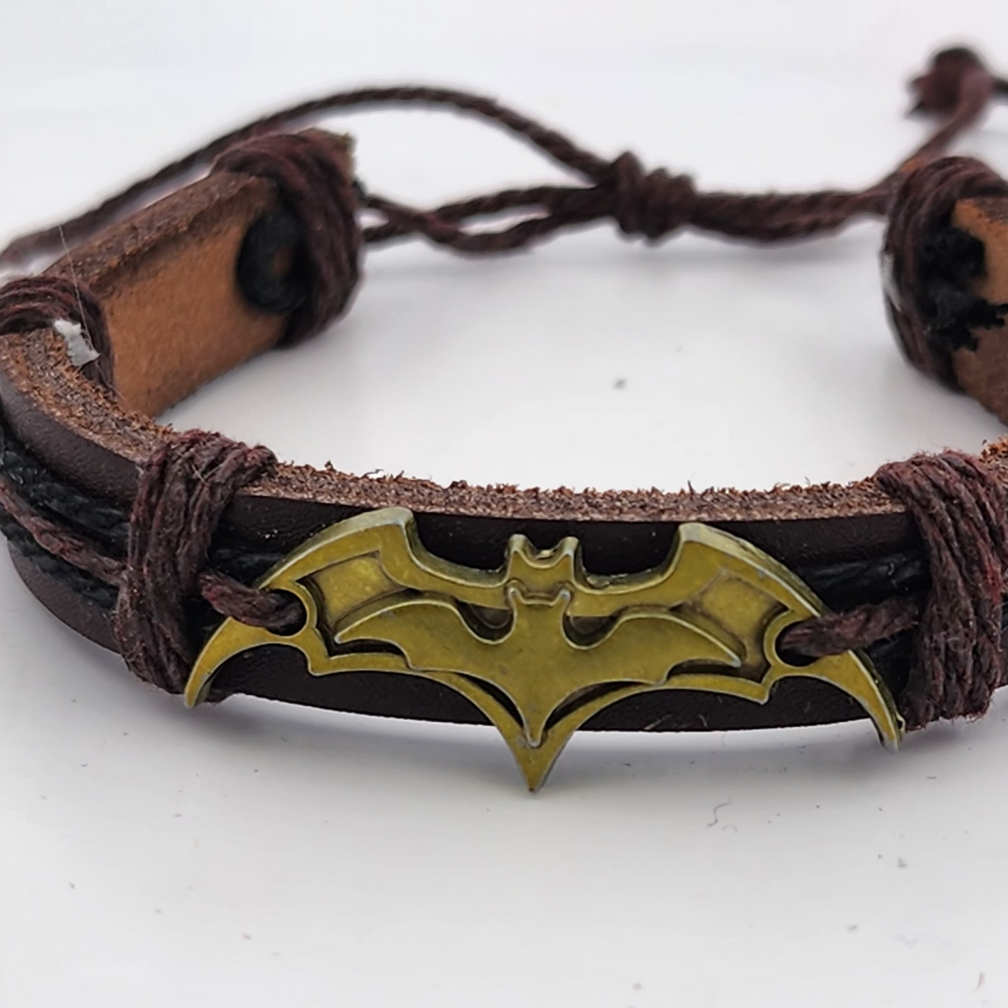 Bracelet with gold bat symbol on a white background