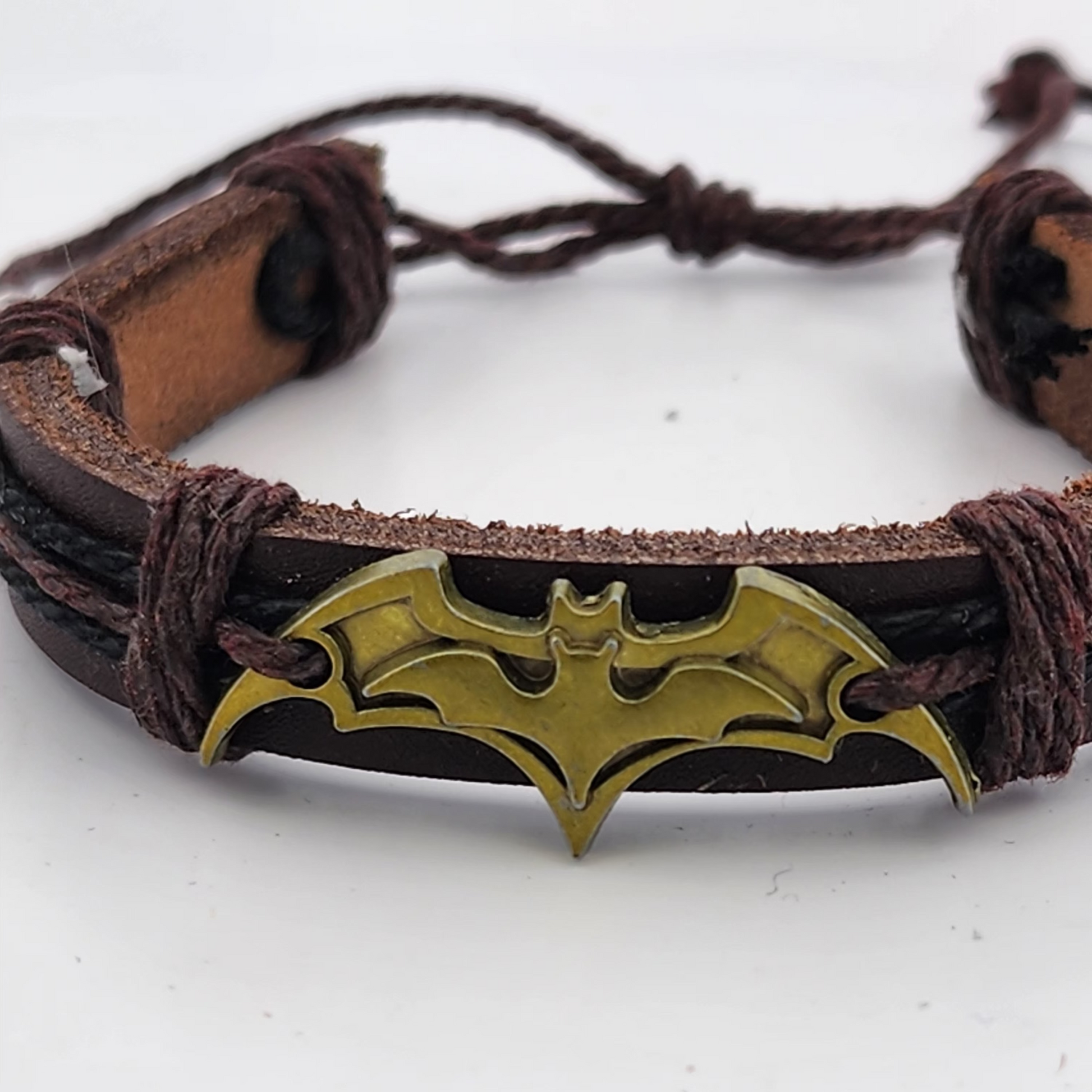 Bracelet with gold bat symbol on a white background