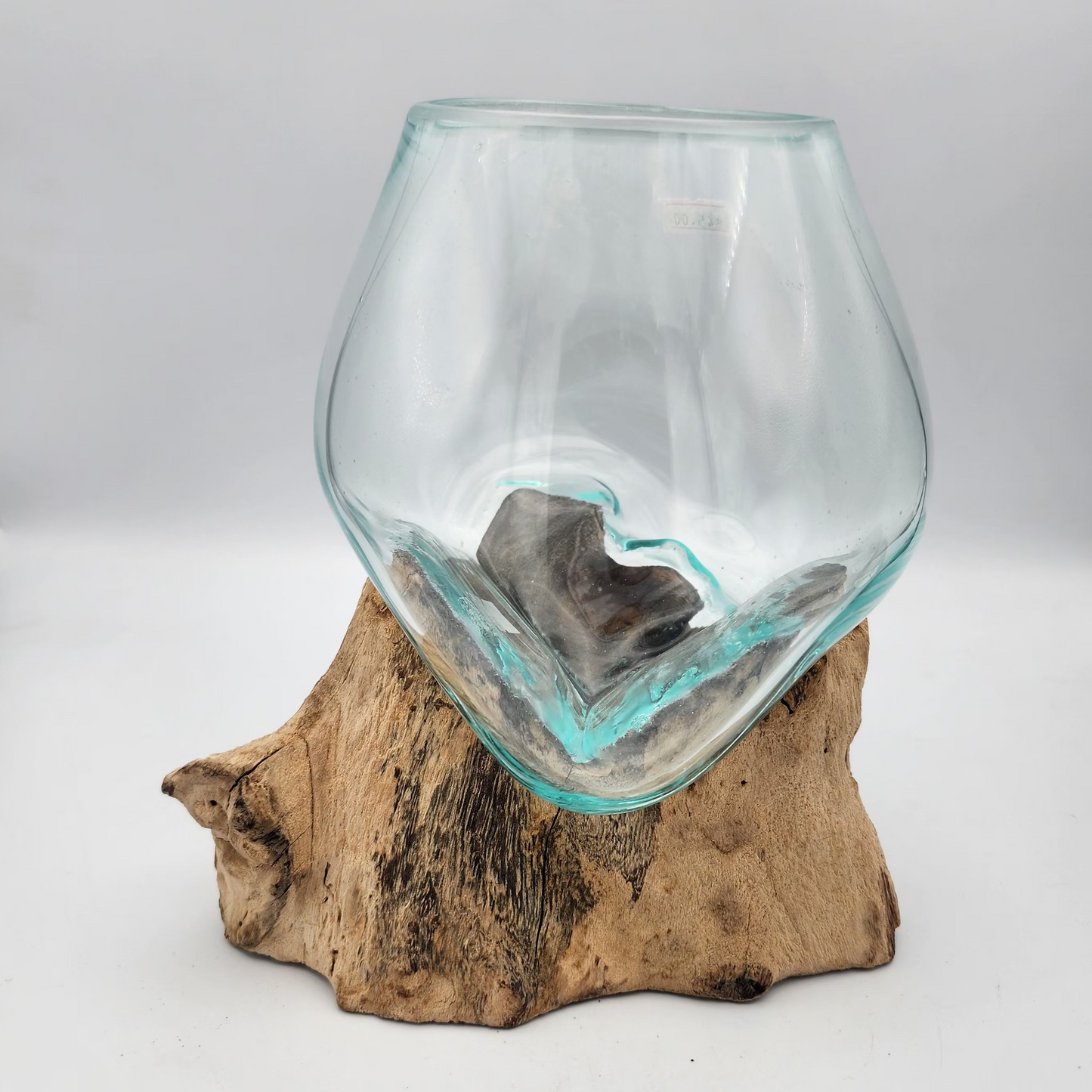 Clear glass vase on a wooden base against a white background