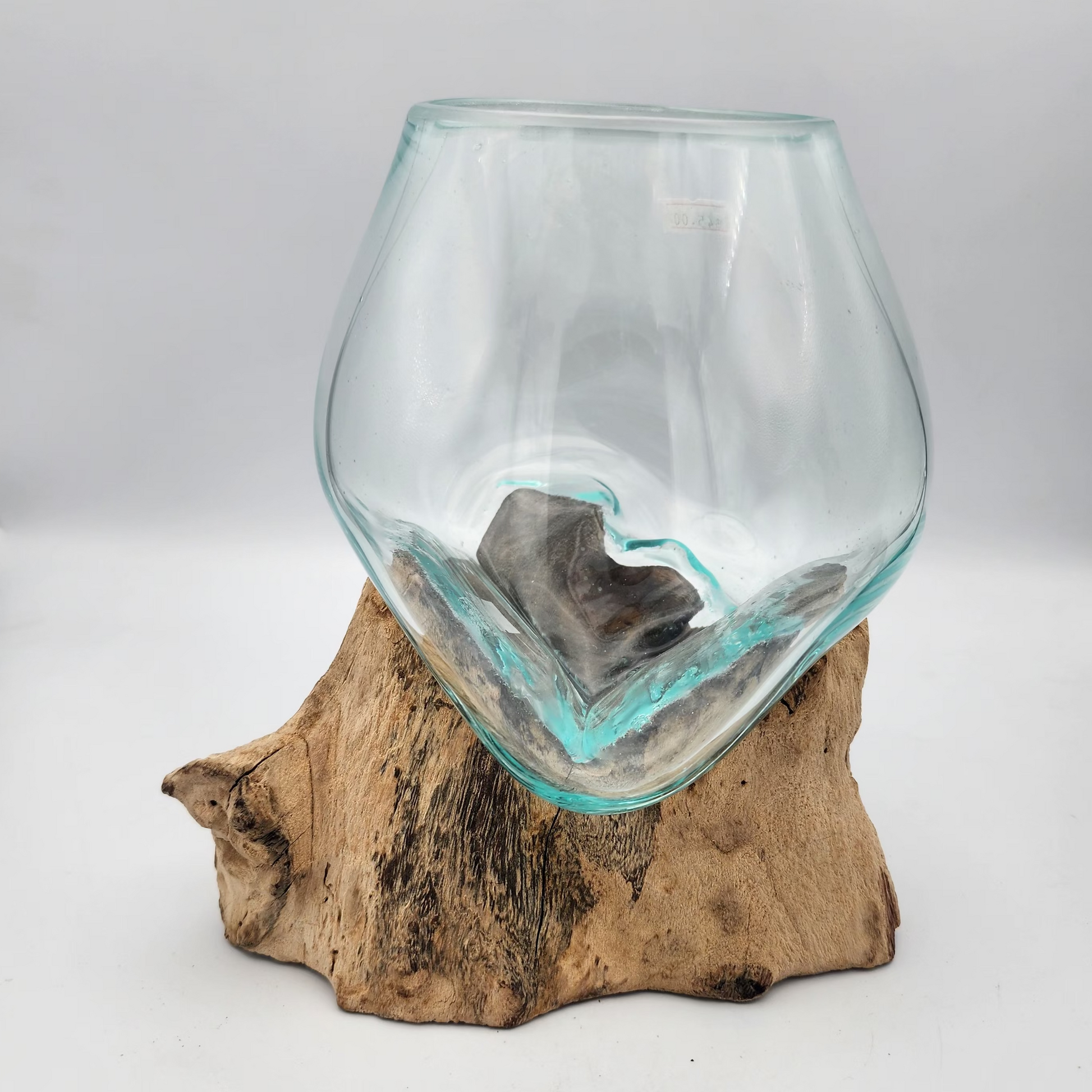 Clear glass vase on a wooden base against a white background