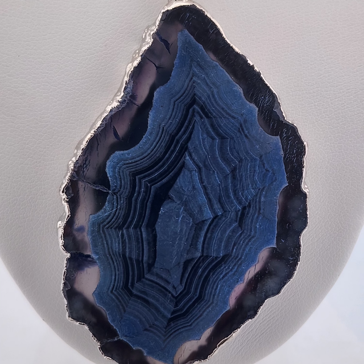 Blue agate pendant on a gray background