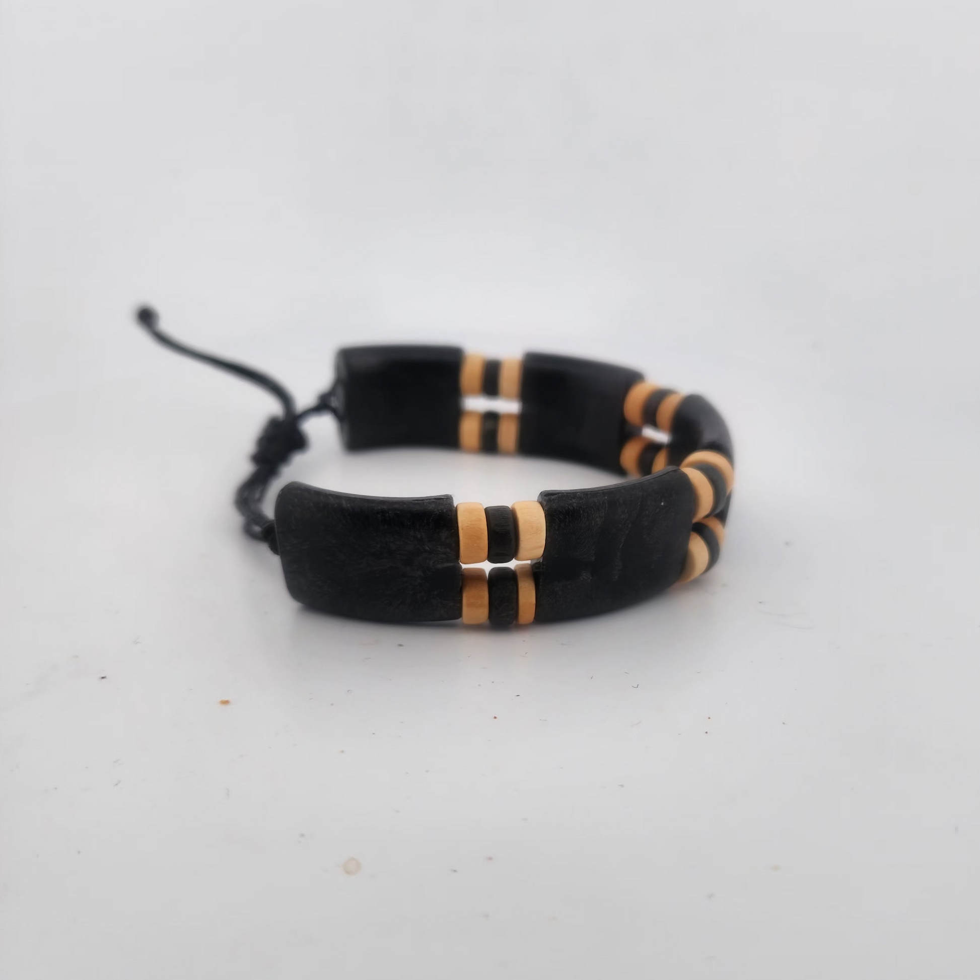 Black bracelet with gold accents on a white background