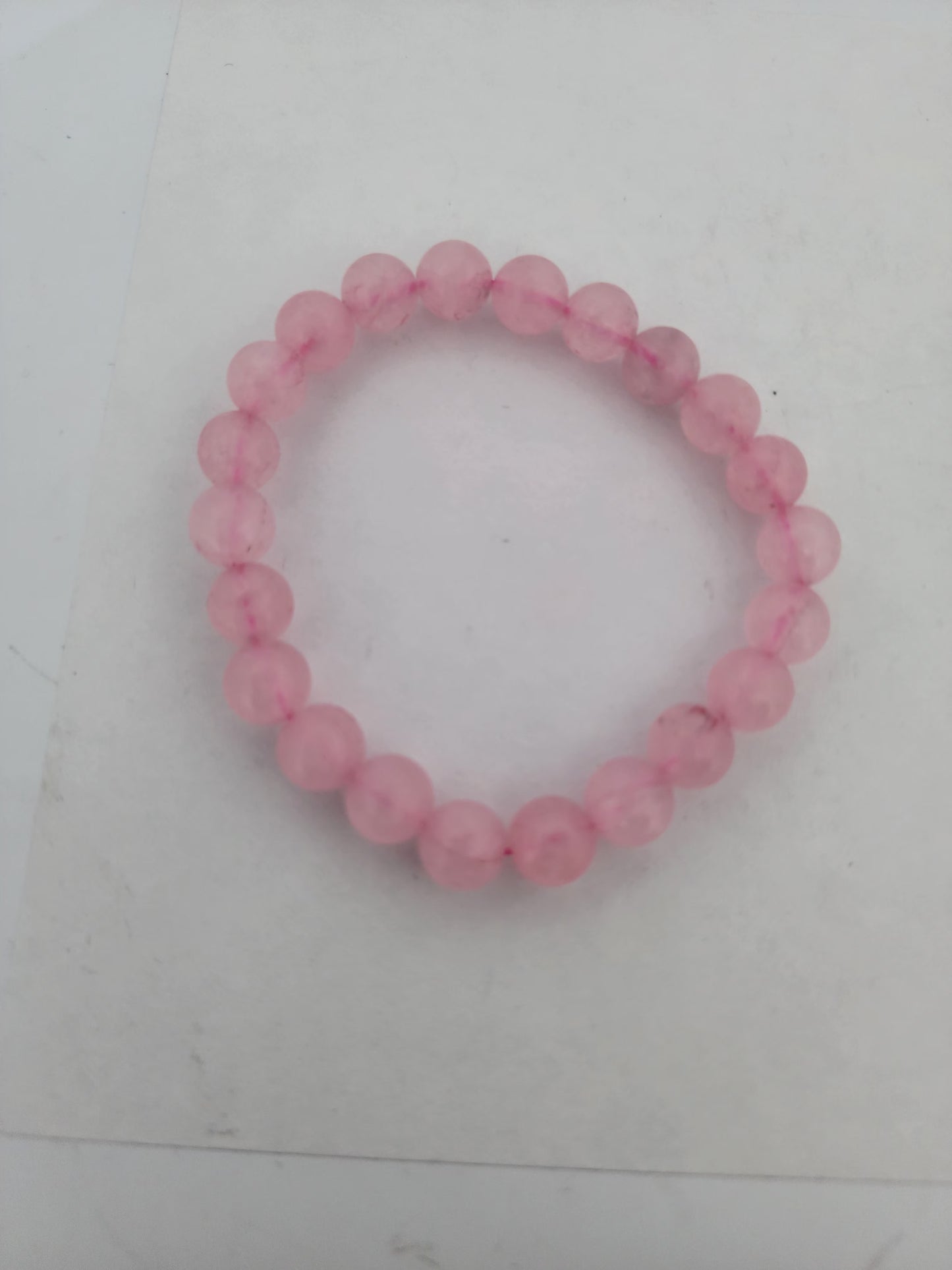 Pink beaded bracelet on a white surface