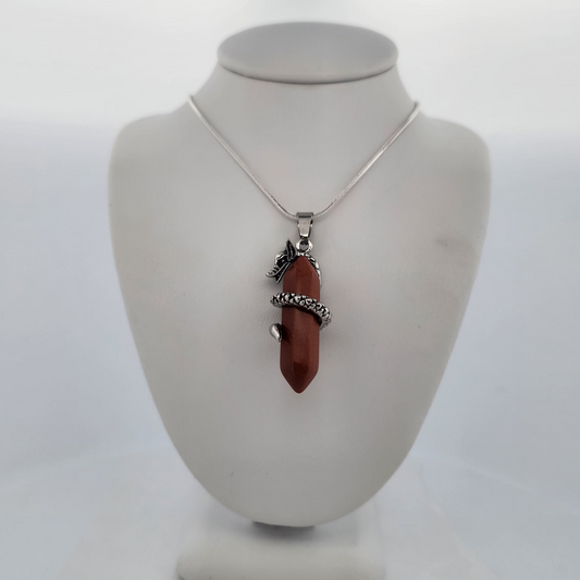 Necklace with a red pendant on a white bust against a white background