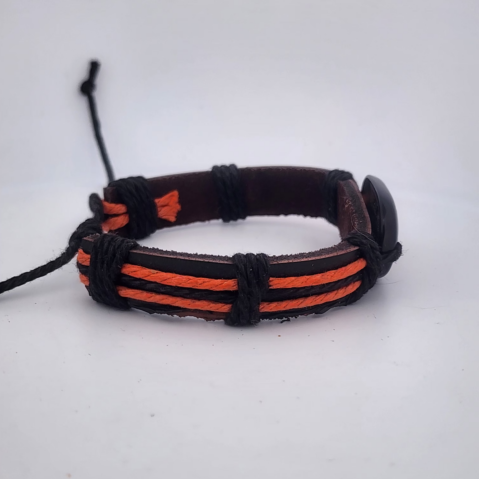 Bracelet with black and orange cord on a white background