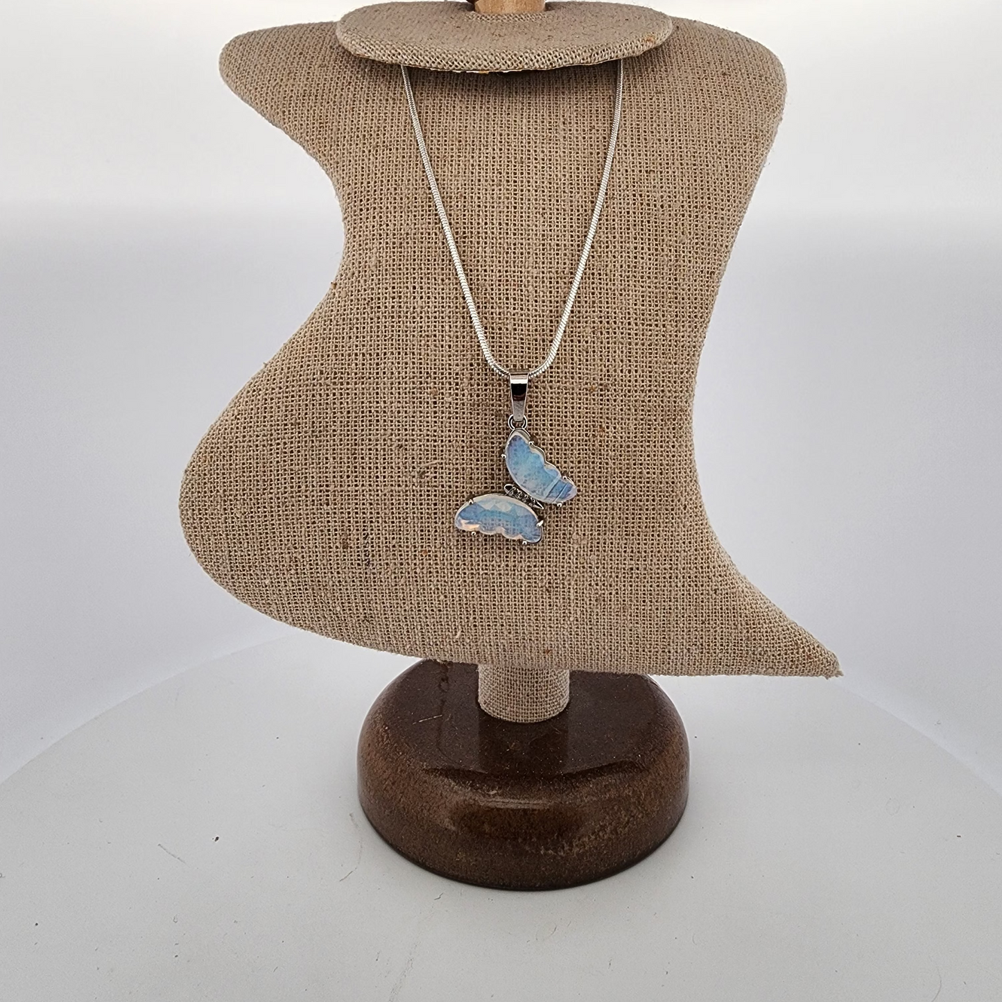 Necklace with a butterfly pendant on a mannequin bust against a white background