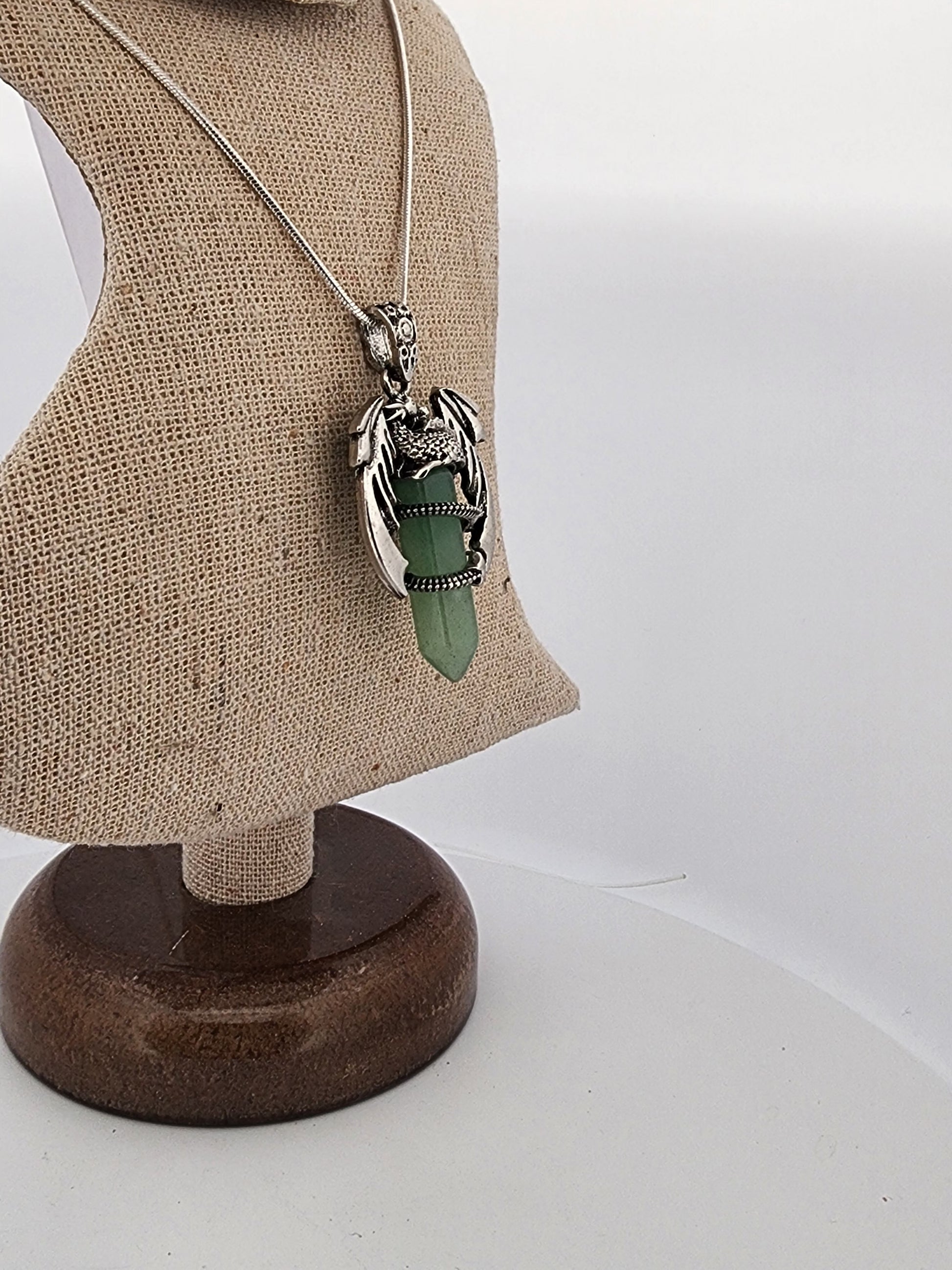 Necklace with a green pendant on a mannequin bust against a white background