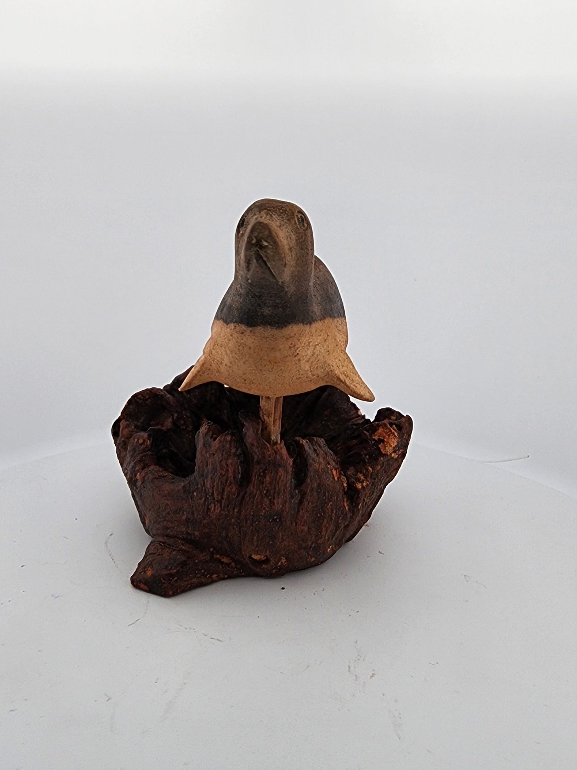 Small ceramic bird figurine on a white background