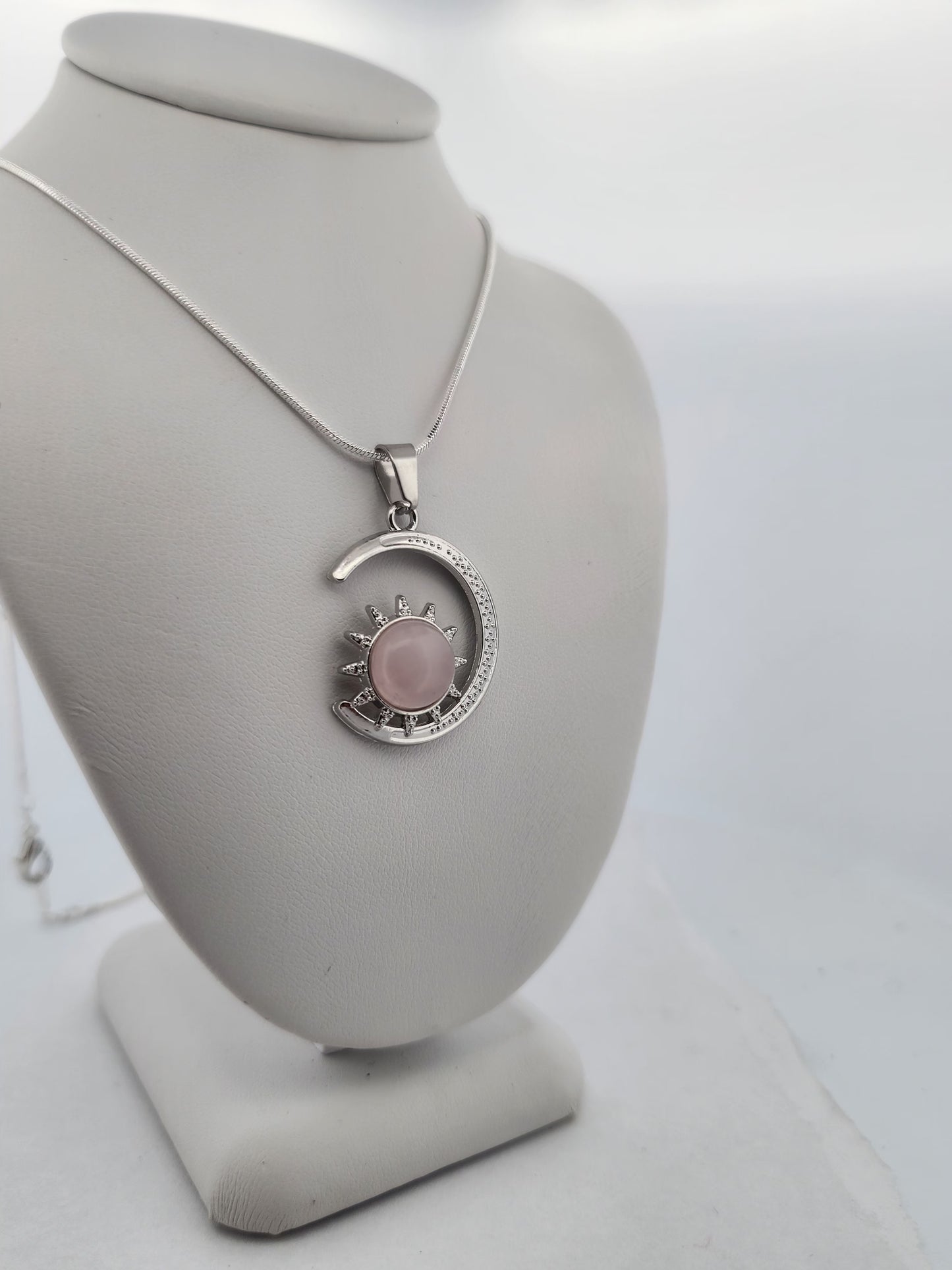 Necklace with a pink pendant on a gray bust