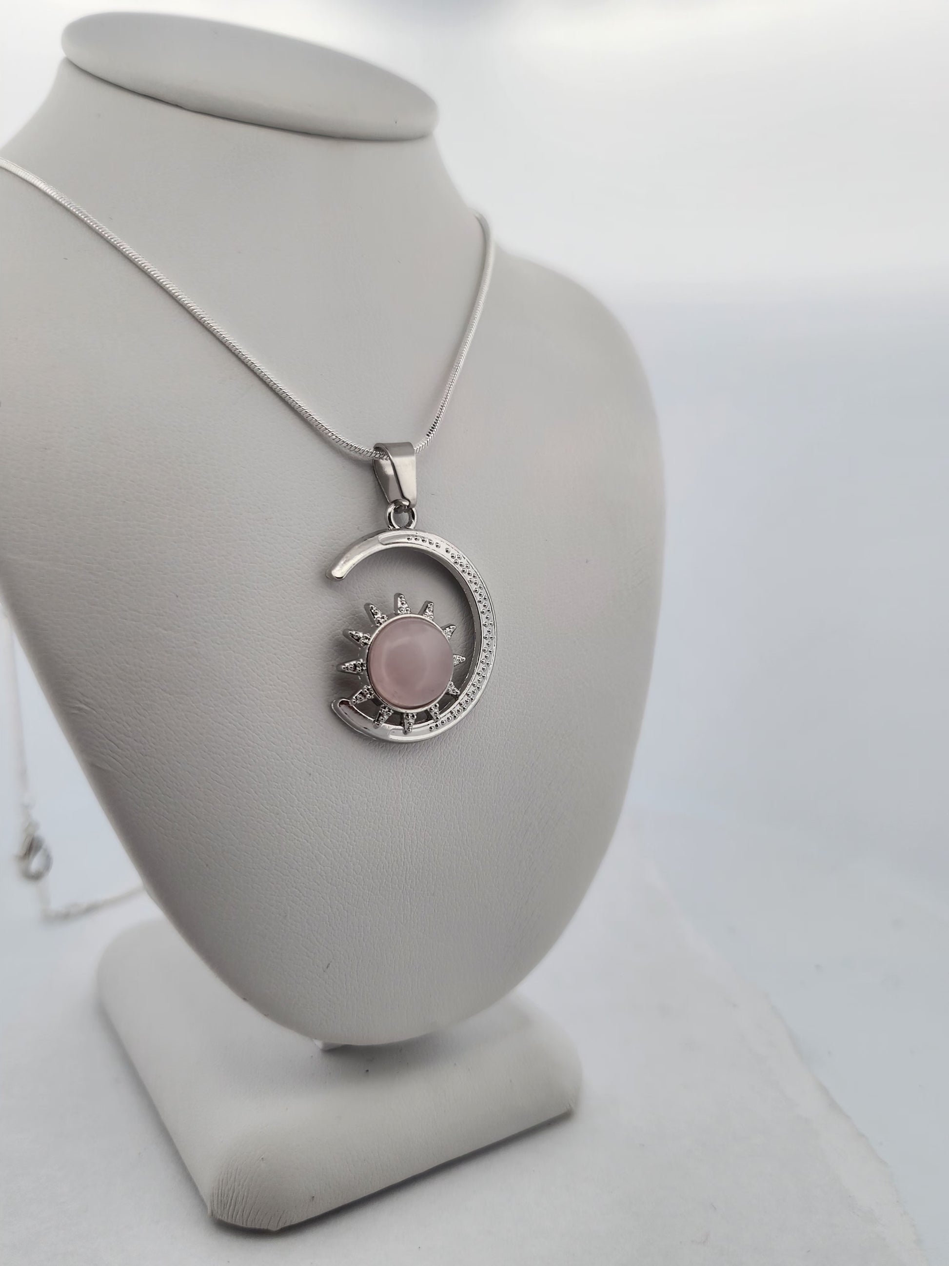 Necklace with a pink pendant on a gray bust